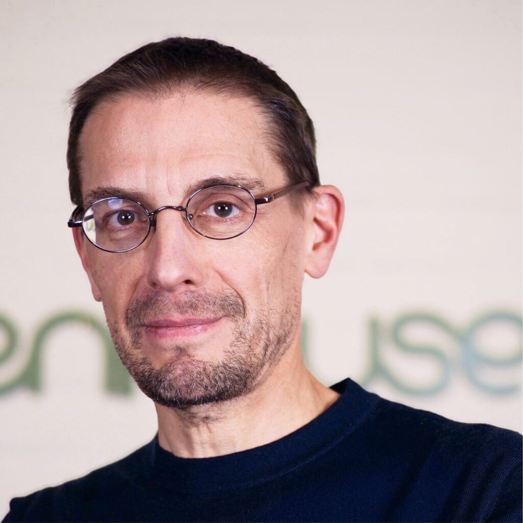 Man in black shirt and glasses smiling at camera